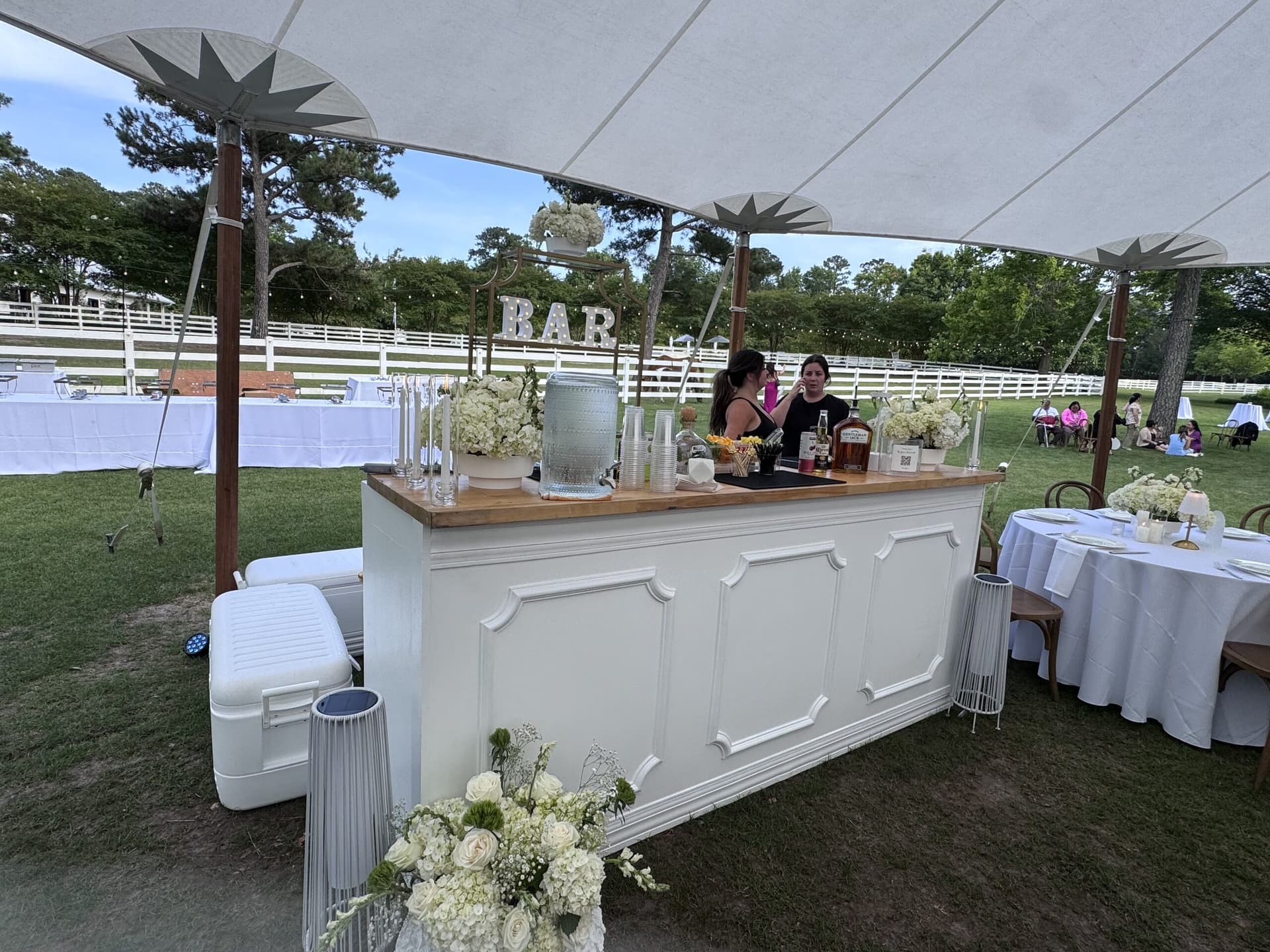 Luxury white mobile bar station at an outdoor tented wedding