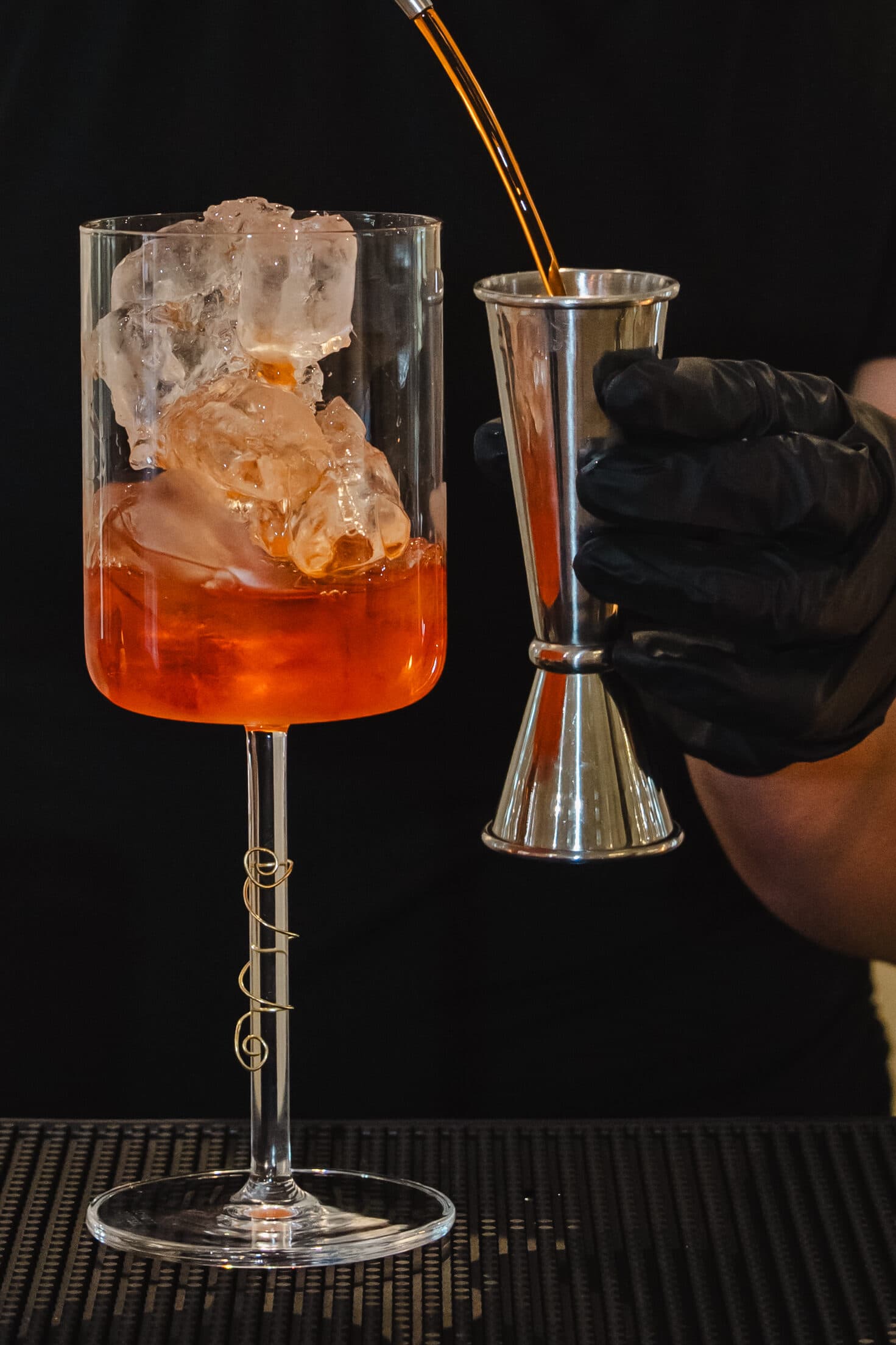 Signature cocktail poured over hand-carved clear ice